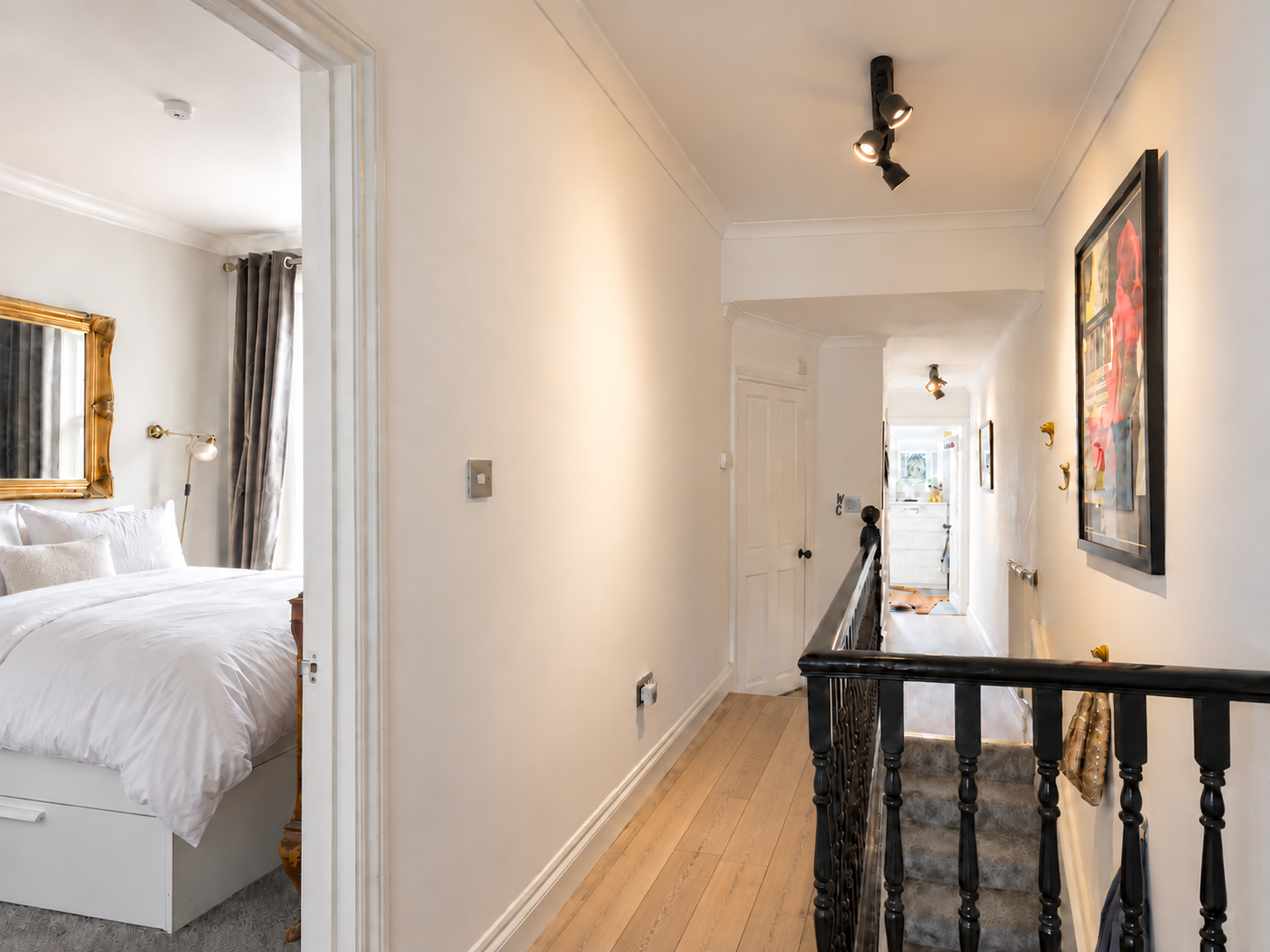 Bright white hallway with natural wooden flooring and a hotel-style bedroom at the renovated Gyllen Properties Co. Manor Road property in Leyton, London