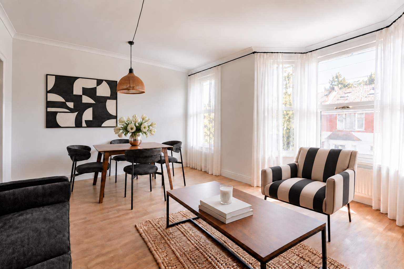 Living and dining room with geometric wall art and white parrot tulips at Gyllen Properties Co.'s Manor Road property in Leyton, London